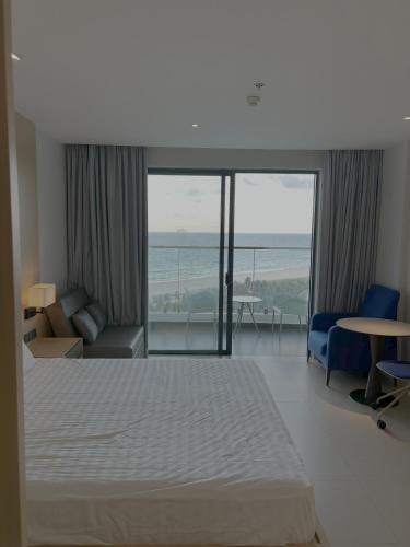 a bedroom with a bed and a view of the ocean at The Arena Resort Beach Front View LightA-0441 in Cam Ranh International Airport