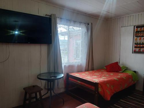 a bedroom with a bed and a window with a table at Hospedaje Luna in Valdivia