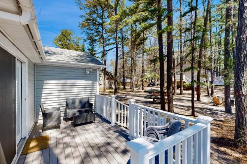 a porch with two chairs and a grill on a house at Bayside Haven in Ossipee