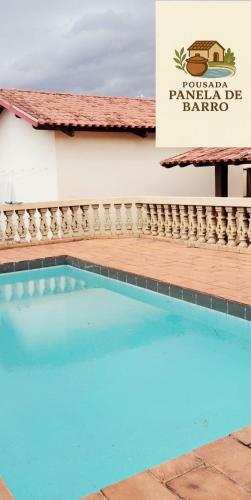 a swimming pool in front of a building with a sign at Hotel Pousada & day use Panela de barro in Barra Bonita