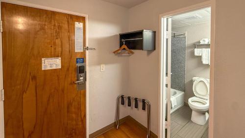 オクラホマシティにあるMotel 6-Oklahoma City, OK - Southのバスルーム(トイレ付)、木製のドアが備わります。