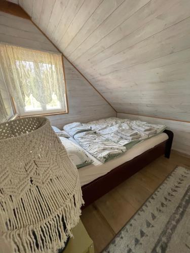 a bed in a small room with a window at Agroturystyka Eden i Raj "Pod rzeźbami" in Krynki