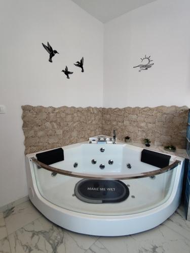 a bath tub in a room with birds on the wall at Valaoritou Luxury Jacuzzi by Dimcol 1 in Thessaloniki