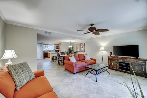 a living room with orange furniture and a flat screen tv at Stones Throw 30 in Hilton Head Island