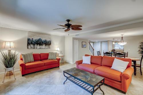 a living room with two red couches and a table at Stones Throw 30 in Hilton Head Island