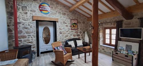 una sala de estar con una pared de piedra en Mont2roux, en Montpeyroux