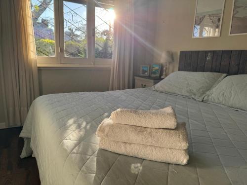 ein Schlafzimmer mit einem Bett mit zwei Handtüchern darauf in der Unterkunft Casa familiar en Carrasco, playa in Montevideo