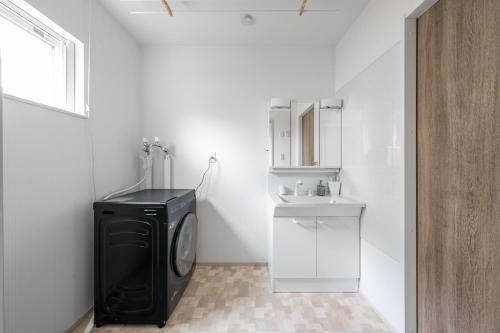 a bathroom with a black washing machine and a sink at THE PASION - Vacation STAY 20146 in Chikabumichō