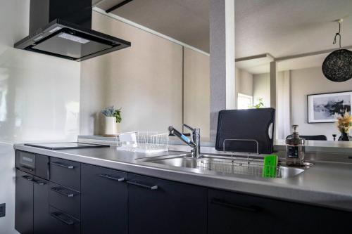 a kitchen with a sink and a large mirror at GROUND BLOOM YIG STAY - Vacation STAY 33641v in Furano