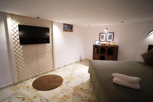 a bedroom with a bed and a flat screen tv at Le Loft Bleu in Rabat