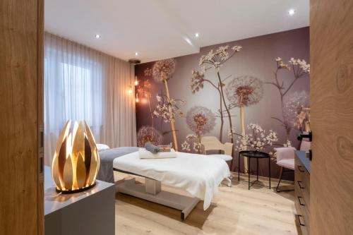 ノイシュティフト・イム・シュトゥーバイタールにあるBergmadl Apartmentsのベッドと花が壁に飾られた病室です。