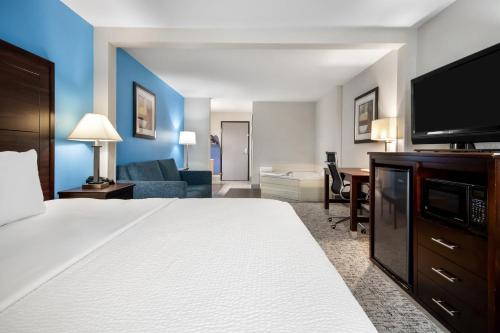 a hotel room with a bed and a living room at Baymont by Wyndham Marinette in Marinette