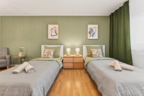 two beds in a room with green walls at NEW Apartment Tina- 2-Zimmer, 4 Einzelbetten, Parkplatz in Buchen