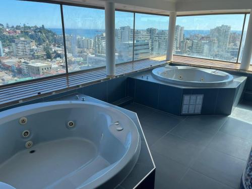 a large bathroom with two tubs and a large window at Steps from Everything in Viña del Mar