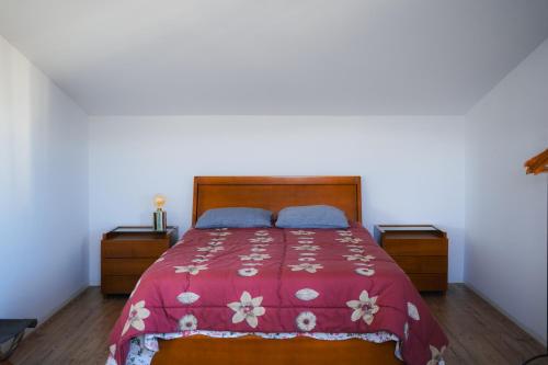 a bedroom with a bed with a red blanket and blue pillows at Casa de Luzes in Amarante