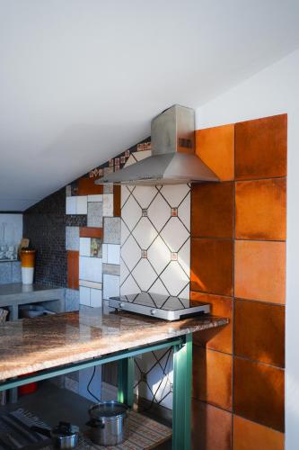 a kitchen with a tile wall with a stove at Casa de Luzes in Amarante