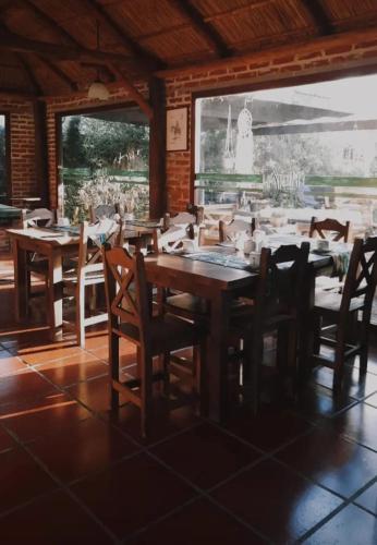 a dining room with wooden tables and chairs in a building at Casas de Campo Hoja in Chascomús