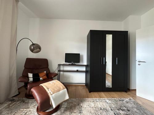 Una sala de estar con una silla y un televisor. en Avella House, en Mühlheim am Main