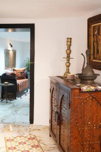 a wooden dresser in a living room with a mirror at Medina Loft Your Artistic Escape in Rabat