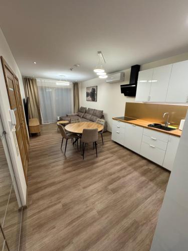 a kitchen and living room with a table and a couch at Lovely Flat with Great Central Location Kaunas in Kaunas