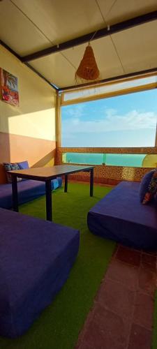 une chambre avec une table et un canapé dans une tente dans l'établissement TISLIT Surf Taghazout, à Taghazout