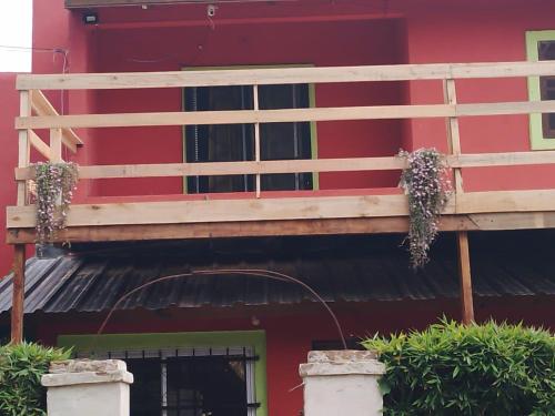 a balcony on the side of a red building with plants at Nuestro Paraiso in Mar del Plata