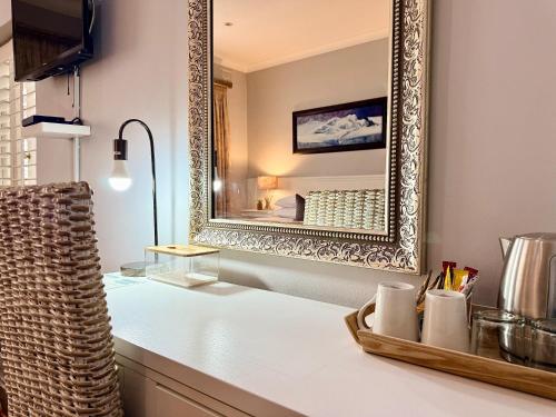 a bathroom with a mirror and a white counter at Musgrave Avenue Guest Lodge in Durban