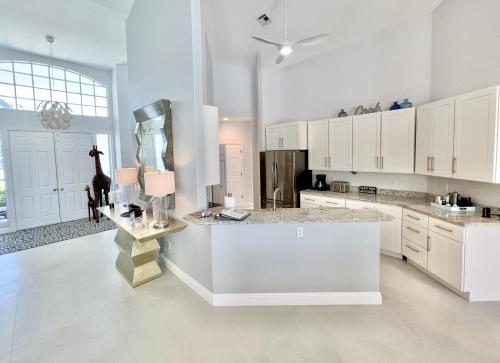 フォートマイヤーズにあるTop Florida Properties Vacation Villasの広いキッチン(白いキャビネット、カウンタートップ付)