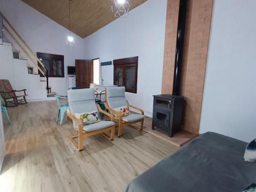 a bedroom with two chairs and a bed and a stove at Casa del arroyo in Caserío Arroyofrío