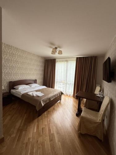 une chambre avec un lit, une table et une chaise dans l'établissement Львівське Передмістя, à Lviv