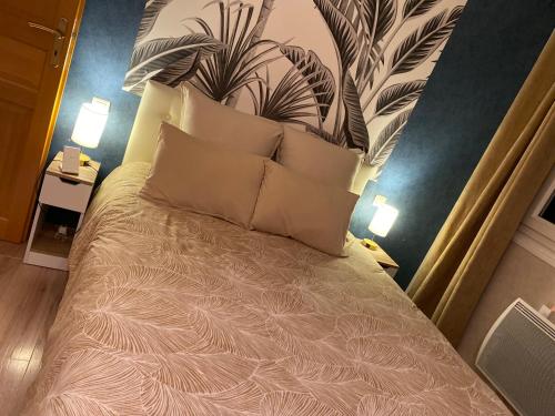 a bedroom with a bed with a large headboard and pillows at Quite House in Villiers-le-Morhier