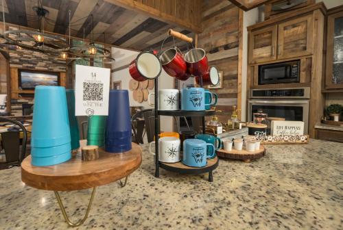 a display of mugs on a table in a kitchen at Wine Time 5 Bedroom Shuffleboard Hot Tub Fire Pit Play Set in Broken Bow