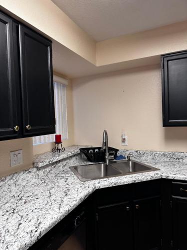 a kitchen with a sink and black cabinets at Arizona cozy place in Mesa