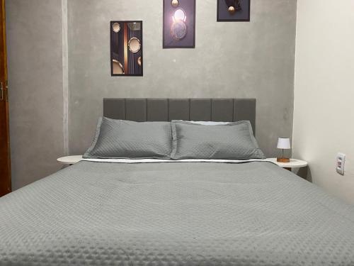 a bedroom with a large bed with four pictures on the wall at Apartamento compartilhado em Guarapuava - Quarto 3 in Guarapuava