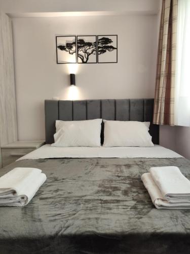 a bedroom with a large bed with two towels on it at Valaoritou Luxury Jacuzzi by Dimcol 3 in Thessaloniki