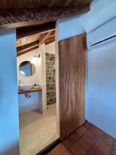 a bathroom with a wooden door and a sink at El monarca in Mompos