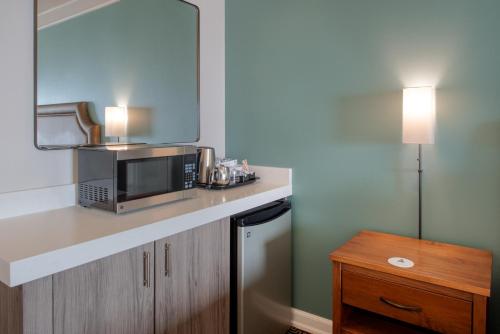 a small kitchen with a microwave and a table at Inn at Nye Beach in Newport