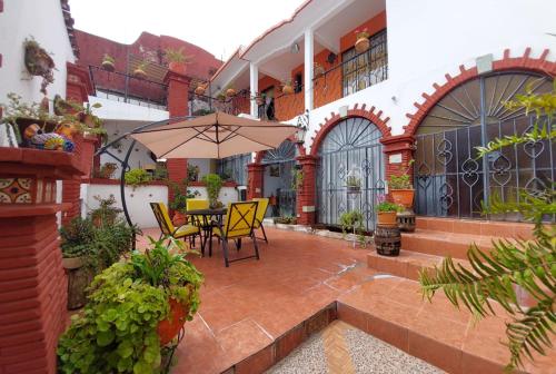 a patio with a table and chairs and an umbrella at Casa en renta, fraccionamiento Victoria, Oaxaca in Oaxaca City