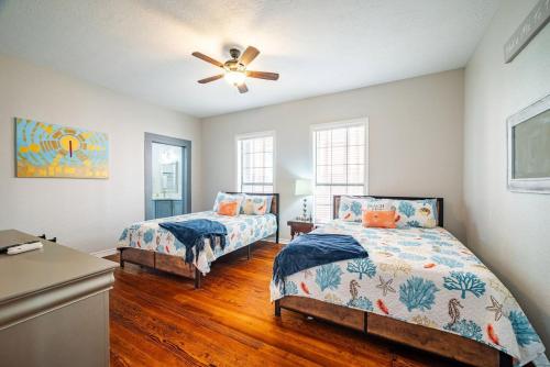 a bedroom with two beds and a ceiling fan at Seawall Sunrise-Close to Beach in Galveston