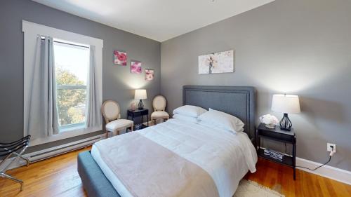 Un dormitorio con una cama grande con dos sillas y una ventana. en Wolfville Central 4 Family Suite with Style, en Wolfville