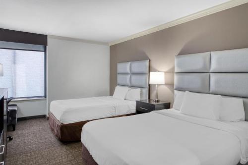 a hotel room with two beds and a window at Best Western Webster Hotel, NASA in Webster