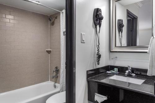 a bathroom with a sink and a toilet and a phone at Best Western Webster Hotel, NASA in Webster