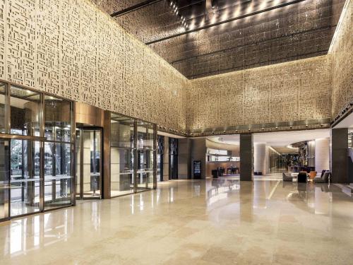 an empty lobby of a building with a tile wall at Novotel Ambassador Seoul Yongsan in Seoul