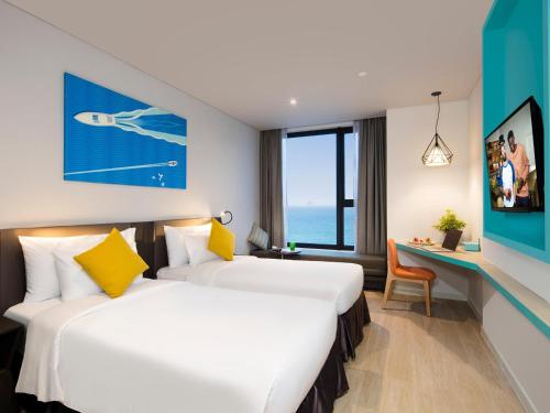a hotel room with two beds and a desk at ibis Styles Nha Trang in Nha Trang