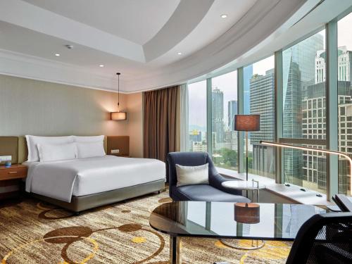 a hotel room with a bed and a large window at Pullman Kuala Lumpur City Centre Hotel & Residences in Kuala Lumpur