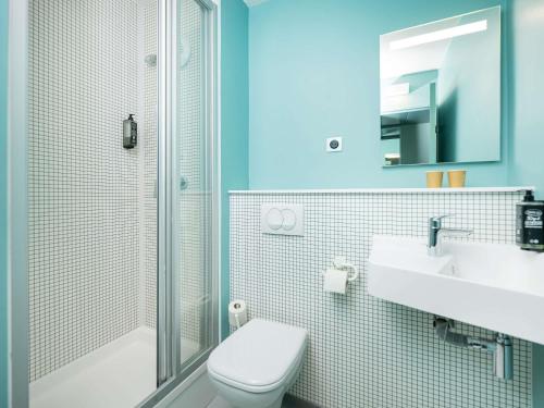 a bathroom with a toilet and a sink and a shower at Ibis Budget Lyon Caluire Cité Internationale in Caluire-et-Cuire