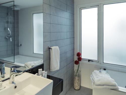 a bathroom with a sink and a mirror at Mercure Montevideo Punta Carretas in Montevideo