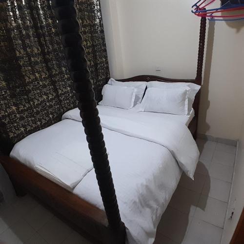 two beds in a room with white sheets and pillows at Langata bnb in Nairobi