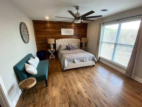 1 dormitorio con cama, sofá y ventilador en Rider's Lodge, en Huntsville