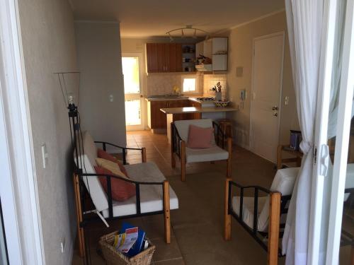 a kitchen with chairs and a table in a room at Ocean View Apartment in Family Complex in Puchuncaví